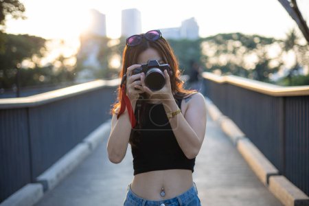 Foto de Fotógrafo asiático mujer tomar al aire libre foto con cámara en ciudad público urbano parque - Imagen libre de derechos