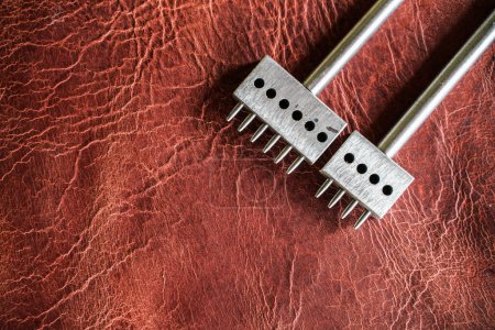 Photo for Metal round puncher tool for leather work and DIY on leather background - Royalty Free Image