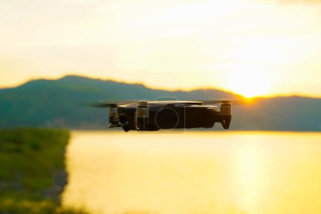 Photo for Silhouette drone flying over lake sunset colorful sky - Royalty Free Image