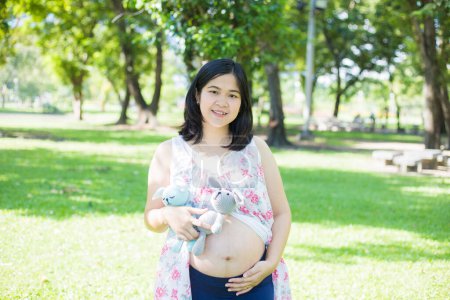 Photo for Asian young happy pregnant woman relaxing and enjoying life in nature park sunshine ligfht hope newborn concept - Royalty Free Image
