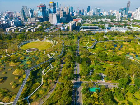 Téléchargez les photos : Vue Aérienne Immeuble de bureaux moderne avec parc tropical verdoyant dans le parc public Benchakitti au centre-ville de Bangkok Thaïlande - en image libre de droit