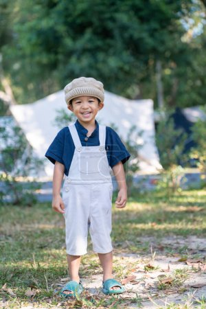 Foto de Feliz kindergarten 5 año asiático chico disfrutando al aire libre camping en selva tropical camping naturaleza vacaciones - Imagen libre de derechos