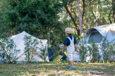 Foto de Feliz kindergarten 5 año asiático chico disfrutando al aire libre camping en selva tropical camping naturaleza vacaciones - Imagen libre de derechos