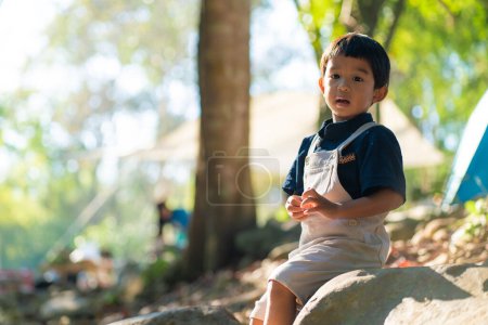 Feliz kindergarten 5 año asiático chico disfrutando al aire libre camping en selva tropical camping naturaleza vacaciones