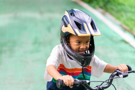 Foto de Kindergarten niño práctica bicicleta en el carril bici parque de la ciudad - Imagen libre de derechos