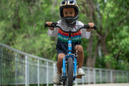 Photo for Kindergarten boy practice ride bicycle in city park bike lane - Royalty Free Image
