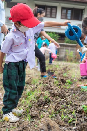 Foto de Kindergarten niño plantación semilla en suelo al aire libre actividad feliz niño naturaleza aprendizaje - Imagen libre de derechos