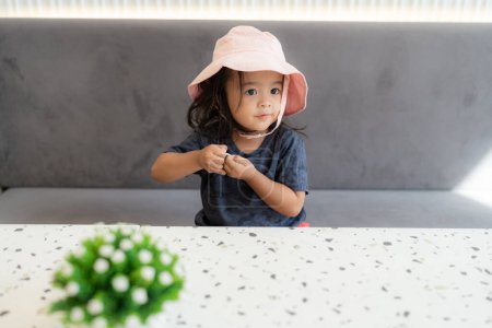 Téléchargez les photos : Petite belle fille maternelle de 3 ans dans un café - en image libre de droit