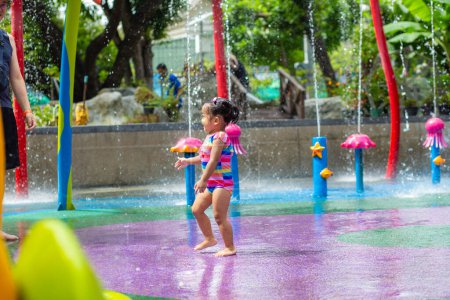 Foto de Adorable niña disfrutando en colorida ciudad parque acuático infantil actividad al aire libre concepto de vacaciones de verano - Imagen libre de derechos