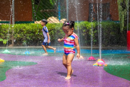 Foto de Adorable niña disfrutando en colorida ciudad parque acuático infantil actividad al aire libre concepto de vacaciones de verano - Imagen libre de derechos