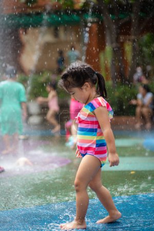 Foto de Hermosa niña adorable disfrutando del juego en el parque acuático al aire libre en el parque infantil de la ciudad - Imagen libre de derechos