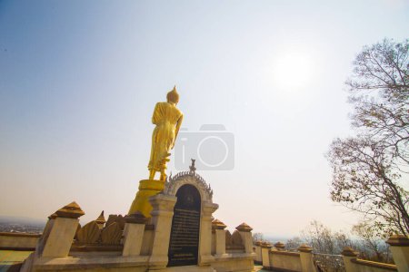 Foto de Estatua de buda dorada de pie en el templo de montaña mirada a la ciudad Nan Tailandia - Imagen libre de derechos
