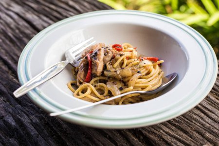 Téléchargez les photos : Spaghettis maison avec porc et piment épicé sur table en bois - en image libre de droit