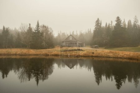 A barn reflecting in a pond on a foggy day on Beals Island, Maine