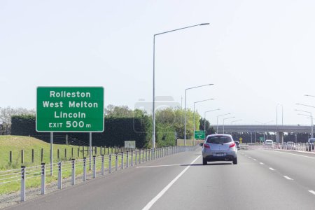 Foto de Rolleston, Nueva Zelanda - 22 de octubre de 2022: Tráfico que viaja a lo largo de la Autopista Sur de Christchurch hacia Rolleston, West Melton y Lincoln, bajo el puente volador de Weedon Street. - Imagen libre de derechos
