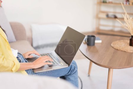 Relaxation concept, Young woman is chatting with friends on laptop while sitting on the couch.