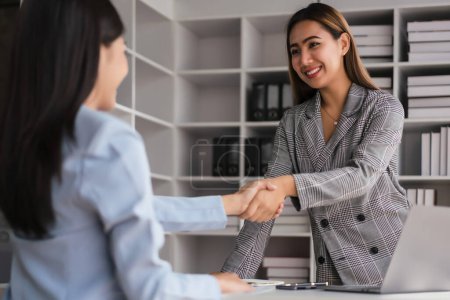 Téléchargez les photos : Deux femmes d'affaires se serrent la main après discussion sur un nouveau projet d'entreprise et traitent ensemble. - en image libre de droit