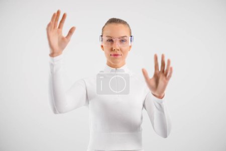 Photo for Portrait of confident young woman wearing smartglasses and gesturing against white background - Royalty Free Image