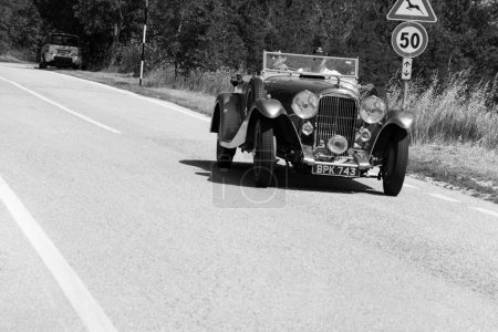 Foto de URBINO, ITALIA - 16 JUN - 2022: LAGONDA M45 RAPIDE 1934 sobre un viejo coche de carreras en el rally Mille Miglia 2022 la famosa carrera histórica italiana - Imagen libre de derechos