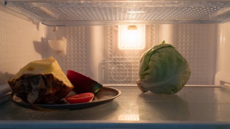 Téléchargez les photos : Fruits and vegetables on the shelf in the fridge, nothing to eat, nighttime gluttony. High quality photo - en image libre de droit