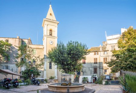 Photo for SAINT FLORENT,FRANCE - SEPTEMBER 7,2023 - Fountain and church of Santa Anna in the streets of Saint-Florent.Saint-Florent is a commune in Haute-Corse department on the island of Corsica, France. - Royalty Free Image