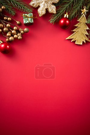 Christmas background design concept, holiday decoration ornament composition with Christmas tree branch, star with copy space isolated on red table.