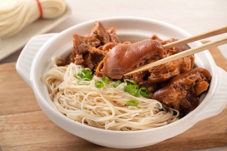 Comida tradicional taiwanesa nudillo de cerdo con vermicelli sobre fondo de mesa de madera.