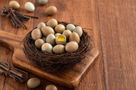 Téléchargez les photos : Oeufs de caille bouton frais dans un nid sur fond de table en bois. - en image libre de droit