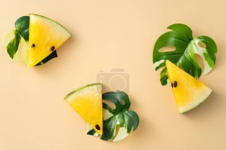 Photo for Sliced yellow golden watermelon with leaves flat lay on pastel yellow table background. - Royalty Free Image