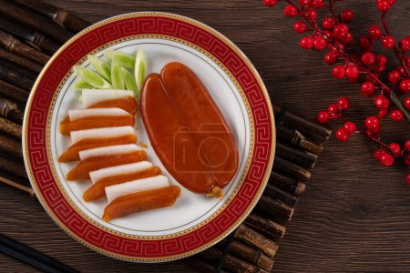 Foto de Delicious fresh mullet roe with white radish slices and garlic sprout for Chinese lunar new year gift basket box, holiday celebration. - Imagen libre de derechos