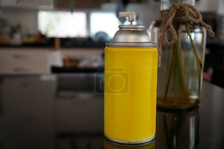 A yellow spray can on the table