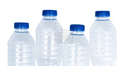 Four plastic water bottles with blue caps.