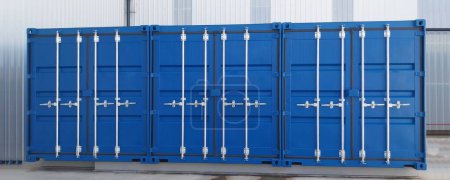 Tres contenedores de envío azul con puertas cerradas.