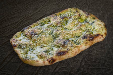 Téléchargez les photos : Italian focaccia bread with pesto, sesame seeds and parmesan. Roman pizza rectangular on wood background - en image libre de droit
