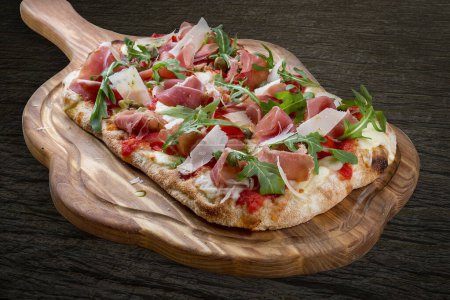 Sorrentina-Pizza mit Schinken, Rucola, Kapern, Pelati-Sauce, Pesto. Römische Pizza rechteckig auf Holz Hintergrund