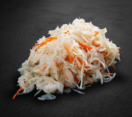 Téléchargez les photos : Chou blanc sauté aux carottes cornichons faits à la main sur un fond de pierre sombre. - en image libre de droit