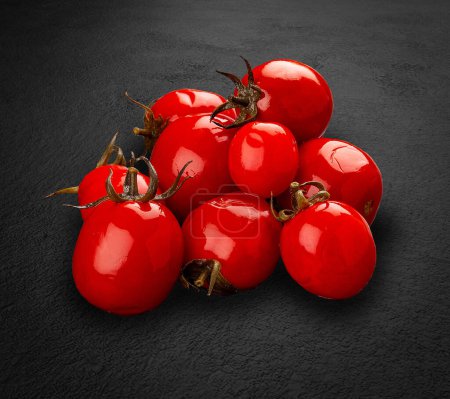 Téléchargez les photos : Tomates marinées, cornichons faits à la main sur fond de pierre sombre. - en image libre de droit