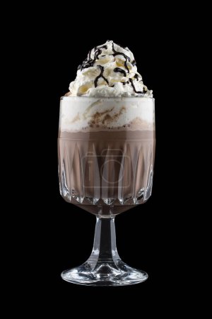 Boisson au café avec crème et sirop de chocolat dans un gobelet en verre original. Isolé sur un fond sombre