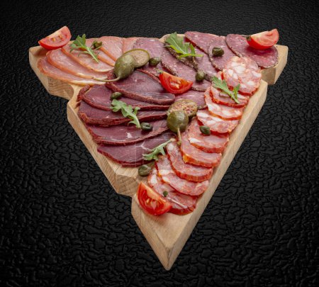 Photo for Board with meat appetizers: basturma, balik, sausage, ham. Isolated image - Royalty Free Image