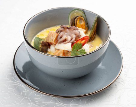 Téléchargez les photos : Soupe crémeuse aux fruits de mer avec saumon, poulpe et moules. Image isolée - en image libre de droit