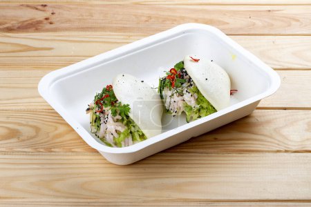 Foto de Bollos de arroz al vapor "Bao" con pollo. Comida saludable. Comida para llevar. Sobre un fondo de madera. - Imagen libre de derechos