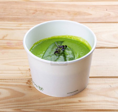 Cream of broccoli soup. Vegetarian food. Takeaway food. On a wooden background.