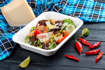 Fitness Caesar Salat mit Huhn. Gesunde Ernährung. Essen zum Mitnehmen. Auf einem hölzernen Hintergrund.