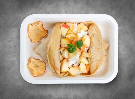 Oatmeal pancake with cottage cheese and spiced apples. Healthy food. Takeaway food. Top view, on a gray background.