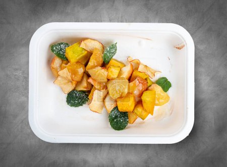 Fruit salad with mint. Healthy diet. Takeaway food.  Top view, on a gray background.