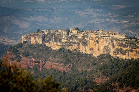 Téléchargez les photos : Vue aérienne du village de Siurana situé au sommet d'une falaise avec vue sur son église se démarquant dans le paysage. Il est entouré de grandes formations de pierre et de forêts. - en image libre de droit