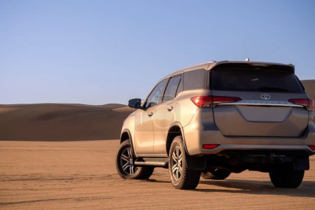 Téléchargez les photos : Toyota Fortuner debout au milieu du désert namibien par une journée ensoleillée. - en image libre de droit