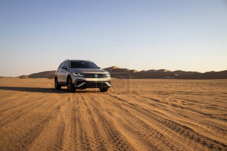 Téléchargez les photos : Volkswagen Tiguan allspace dans le sable du désert namibien à un ciel lumineux. Walvis Bay, Namibie. - en image libre de droit