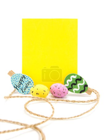 Greeting blank card with rope on clothespins with colored eggs. Copy space. Free space for text. Happy easter!
