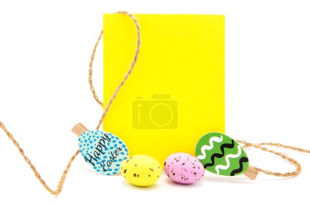 Greeting blank card with rope on clothespins with colored eggs. Copy space. Free space for text. Happy easter!